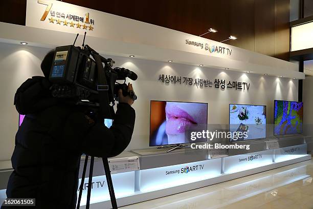 Cameraperson films Samsung Electronics Co.'s F8000 series smart televisions as they are displayed at a media event in Seoul, South Korea, on Tuesday,...