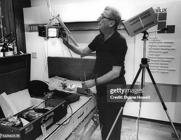 Sam Blake of the Luxo Lamp Co. At the Electrical-Electronic Trade Show in Denver, prepares an exhibit in which three firms participate to aid...