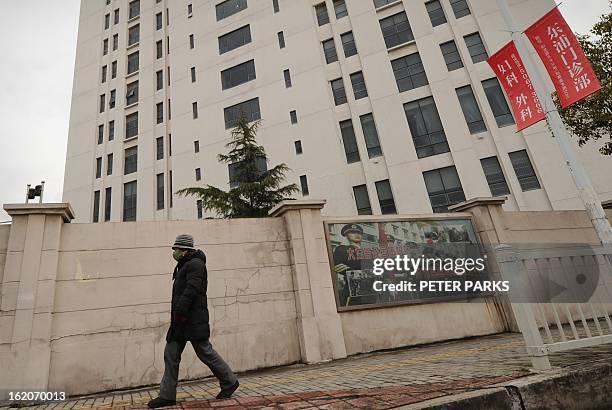 Person walks past a 12-storey building alleged in a report on February 19, 2013 by the Internet security firm Mandiant as the home of a Chinese...