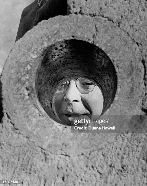 Dr. John C. Rowley, sub terrene cores system project chief looks through hole made by cores.;;