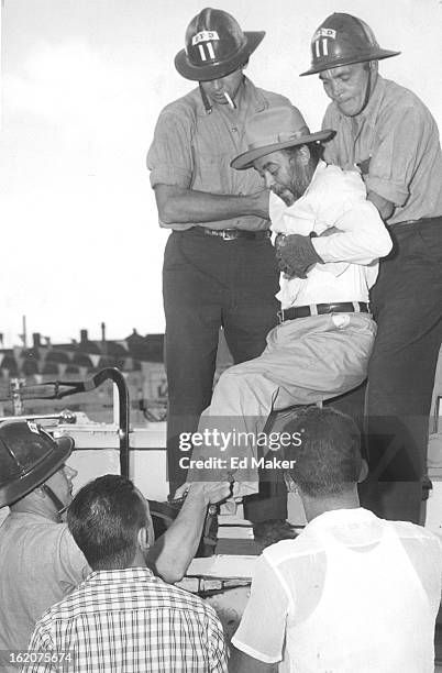 Denver - Crippled with arthritis, bearded Eloy Maes is helped by firemen Vern Hansen and Tad Hannigan from the 25-foot platform on which he spent 45...