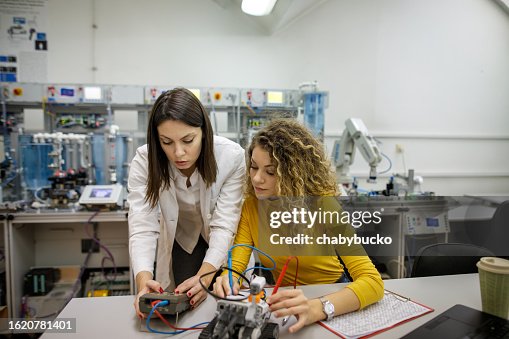 Student learning from engineer how to work with electronic instrument Student learning from engineer how to work with electronic instrument