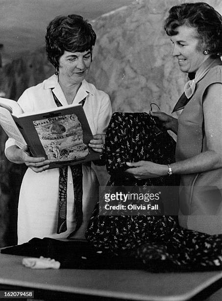 Library Volunteers Identity Historic Clothes; Mrs. John Dawson, 6177 S. Windermere Way, holds catalog while Mrs. Hugh Monteith, 6463 S. Franklin St.,...