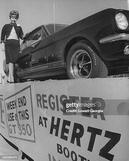 Business Exhibit Prize; Prisci I la Berry, Denver saies representative for Hertz Rent A Car at Denver displays the Ford Mustang given for a weekend...