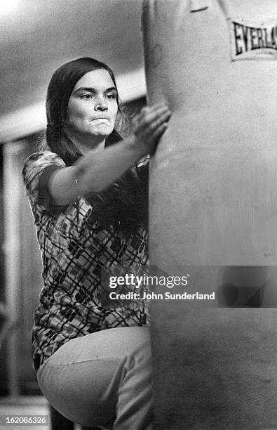 She is pretending to be boxing an assailant's ears while kicking him in the groin.;