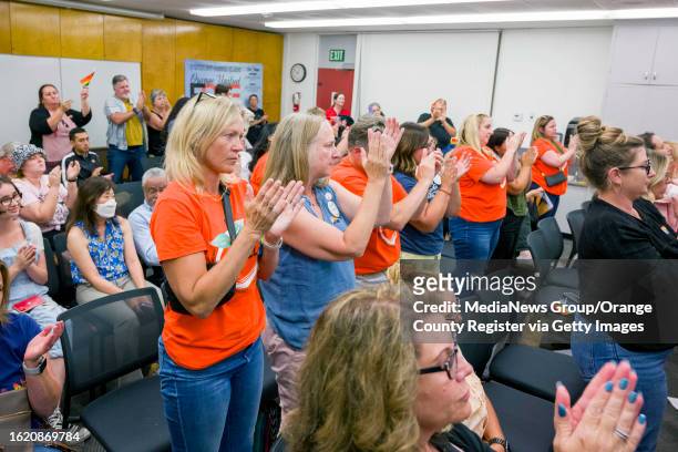 People opposing the proposed policy give board member Kris Erickson as standing ovation after she eloquently spoke out against the proposal during a...