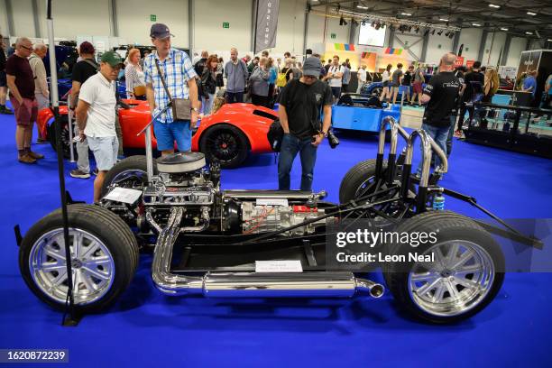 Visitors look at the stripped-back chassis and engine system of an XCS Designs 427 Capello during the first day of the British Motor Show at...