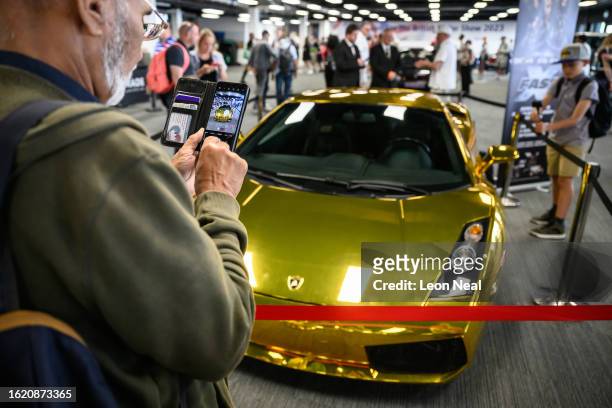 Visitors take photographs of the gold 2003 Lamborghini Gallardo featured in the latest chapter of the Fast & Furious franchise, "Fast X", on the...