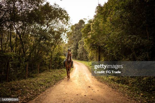 young woman horseback riding on a forest - horseback riding stock pictures, royalty-free photos & images