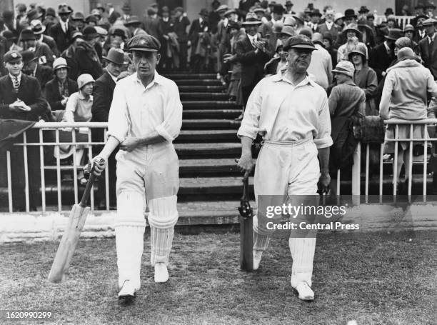 Team captain Herbie Collins and Warren Bardsley of the touring Australian cricket team walk onto the field wearing their baggy green caps during the...