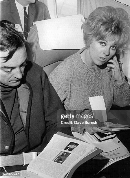 En route to Aspen, Colo., actress Kim Novak and actor Richard Johnson stopped briefly in Denver. They are pictured in a Frontier Airlines plane...