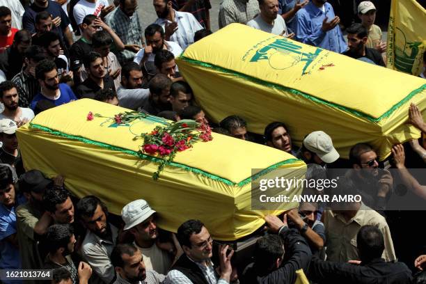 Relatives and comrades of two Hezbollah fighters carry their coffins during their funeral procession in the southern Lebanese town of Nabatiyeh, 15...