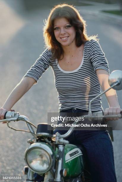 Jackie Fox, bassist in "The Runaways", posing on a bike, United States, circa 1970s.