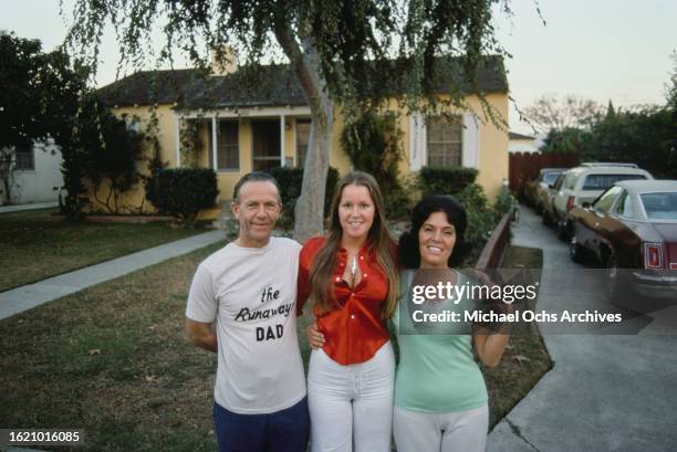 Lita Ford guitarist in "The Runaways" posing with her parents Len and Lisa at her family home, Los Angeles, California United States, circa 1970s.