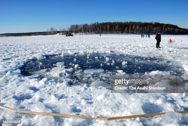 Hole, thought to be made by the fragment of the meteor in the ice of Chebarkul Lake is seen on February 16, 2013 some 80 kilometers from Chelyabinsk,...