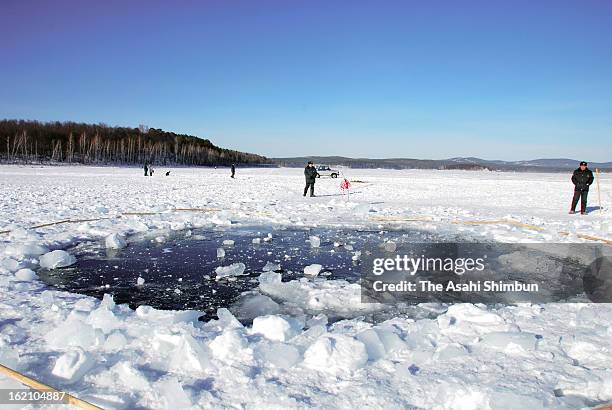 Hole, thought to be made by the fragment of the meteor in the ice of Chebarkul Lake is seen on February 16, 2013 some 80 kilometers from Chelyabinsk,...