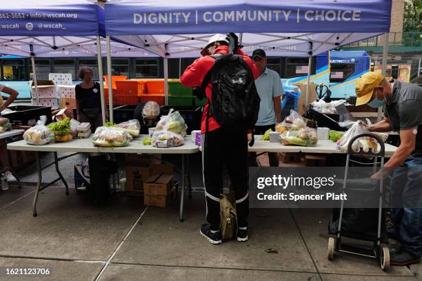 Volunteers and employees with West Side Campaign Against Hunger distribute food to those in need outside of their Manhattan facility on August 17,...