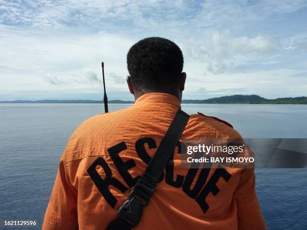 Member of a rescue team looks out at North Pagai island as the ship brings relief aid and assistance to the victims of a 7.7-magnitude quake...