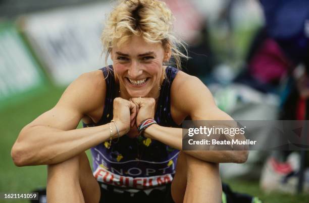 German athlete Heike Drechsler smiling with her chin resting on her hands during the women's long jump event of the 1992 German Athletics...