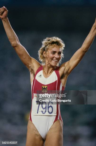 German athlete Heike Drechsler, her arms outstretched, celebrates after winning gold in the women's long jump event at the 1992 Summer Olympics, held...
