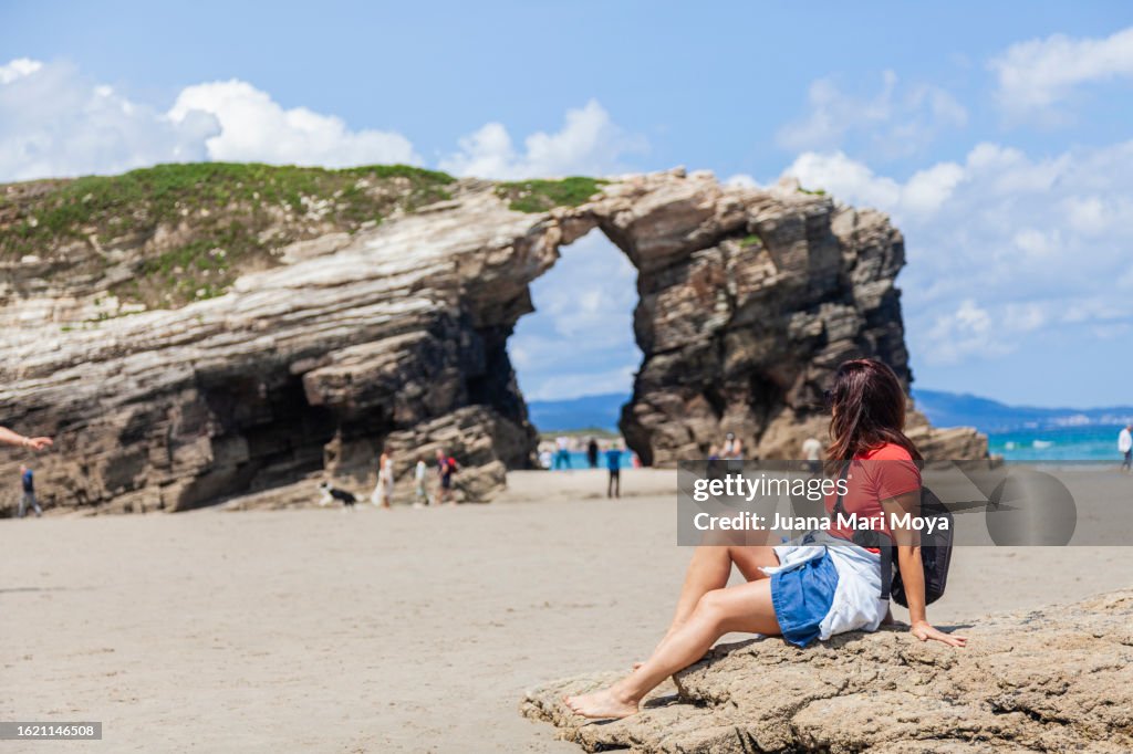 Tourist exploring and contemplating "La playa de las Catedrales" in Ribadeo, province of Lugo.