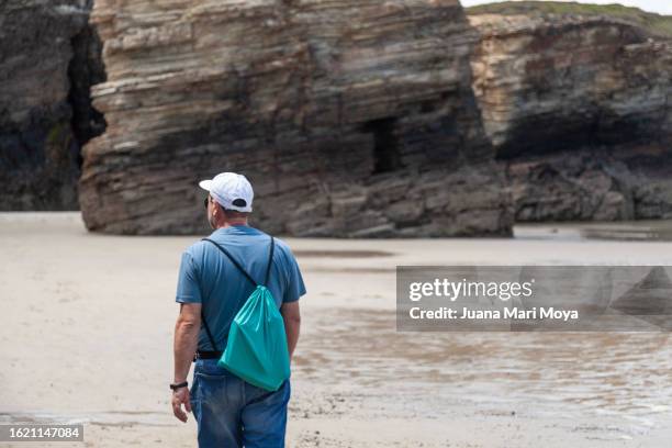 tourist exploring and contemplating "la playa de las catedrales" in ribadeo, province of lugo. - provincia de lugo ストックフォトと画像