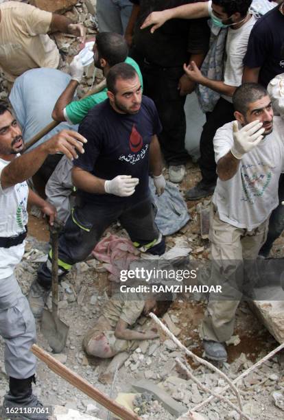 Rescuers call for help, 08 August 2006, after finding the dead body of a Lebanese teenager in the rubble of a building hit by an Israeli strike in...