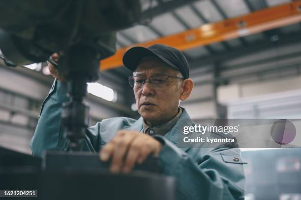 ouvrier industriel senior travaillant à l’usine - retraités qui travaillent photos et images de collection