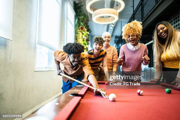 collègues/amis jouant au billard après le travail dans la salle de billard au bureau - billard photos et images de collection