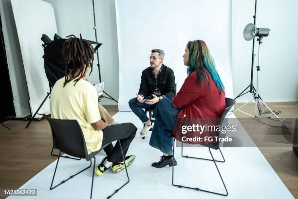 coworkers talking during a meeting at studio - diverse film set stock pictures, royalty-free photos & images