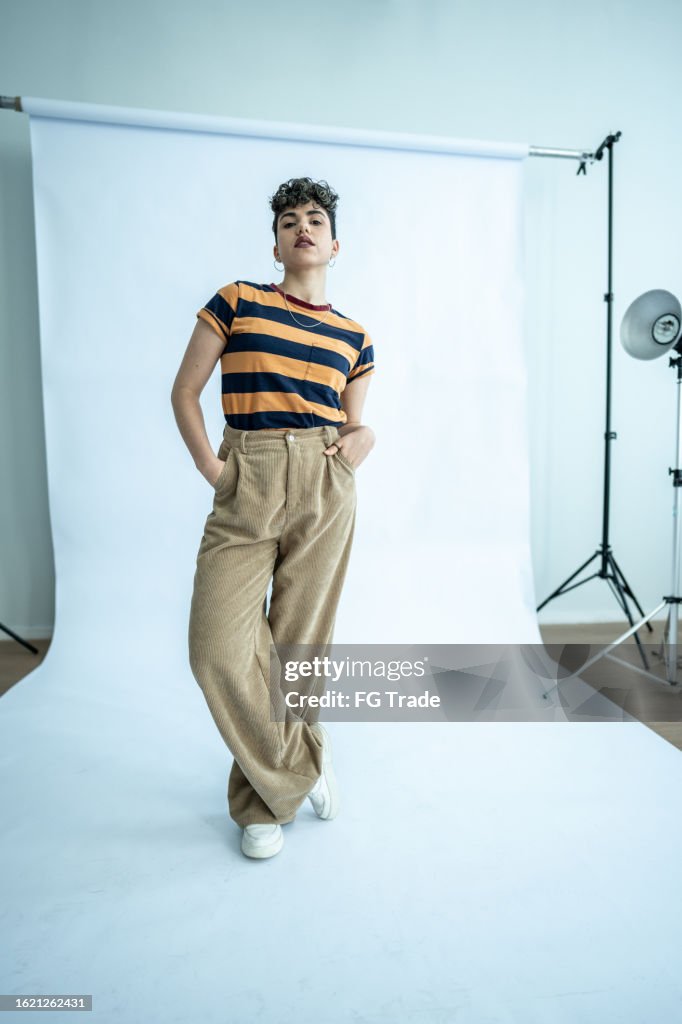 Porträt einer jungen Modellfrau mit Händen in Taschen im Atelier