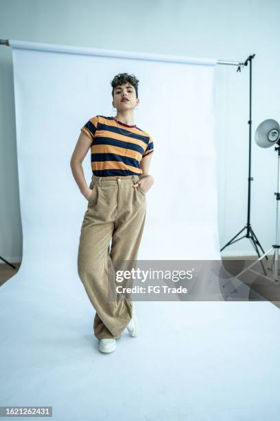 portrait of a young model woman with hands in pockets at studio - sessão fotográfica imagens e fotografias de stock