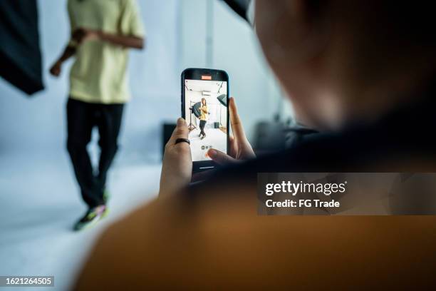 fotógrafo tomando fotos/filmando a una modelo bailando en el estudio - rodar películas fotografías e imágenes de stock