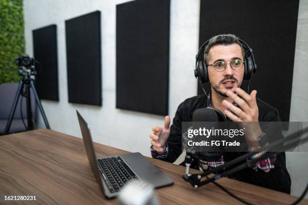 mid adult man talking during a interview at podcast - radio studio stock pictures, royalty-free photos & images