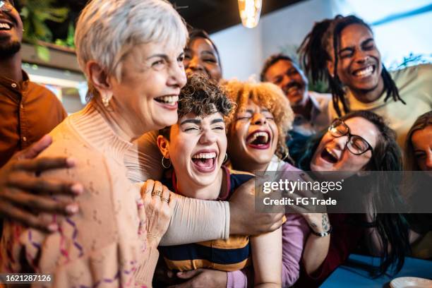 amici felici che si abbracciano in ufficio - happy hour foto e immagini stock