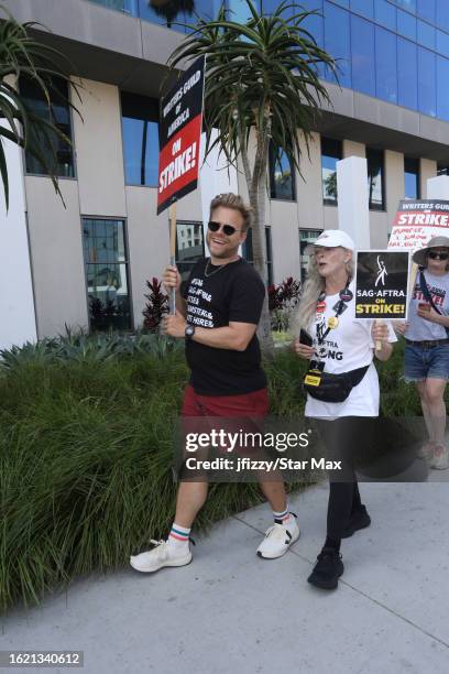 Adam Conover and Frances Fisher walk the picket line in support of the SAG-AFTRA and WGA strike outside of Sunset Bronson Studios on August 24, 2023...