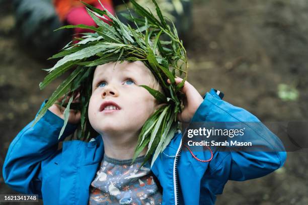 little boy looking up wearing a leaf crown - plant part stock pictures, royalty-free photos & images