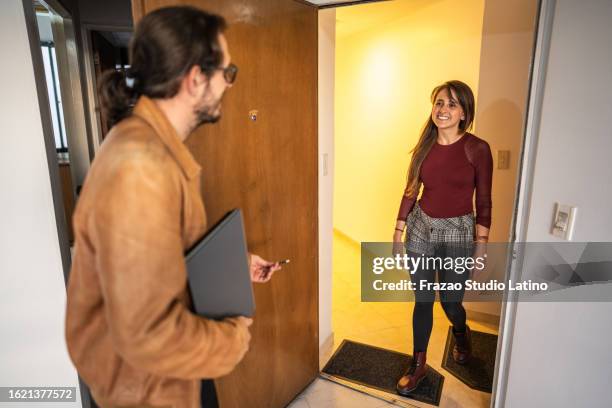 friends welcoming or customer talking to real estate agent when she's entering at apartment - röra mot bildbanksfoton och bilder
