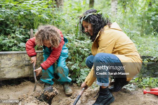 mother and daughter digging holes in the sand at forest school - british crown stock pictures, royalty-free photos & images