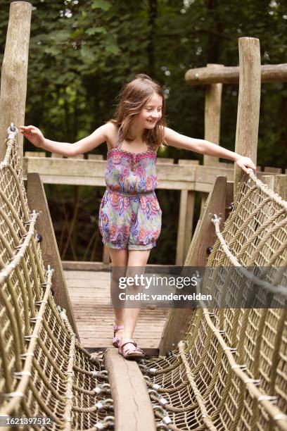 six-year-old girl exercising on climbing equipment - hanging bridge stock pictures, royalty-free photos & images