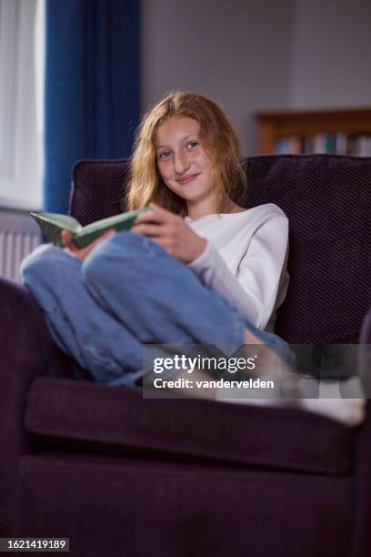 girl with red blonde hair reading a book - curled up reading stock pictures, royalty-free photos & images