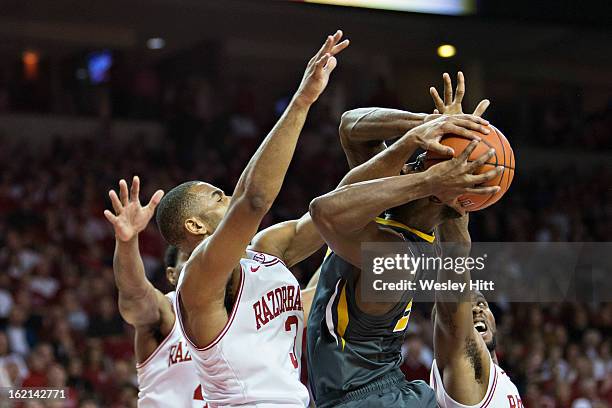 Rickey Scott of the Arkansas Razorbacks blocks the shot of Keion Bell of the Missouri Tigers at Bud Walton Arena on February 16, 2013 in...