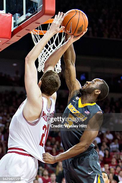 Keion Bell of the Missouri Tigers blocks the shot of Hunter Mickelson of the Arkansas Razorbacks at Bud Walton Arena on February 16, 2013 in...