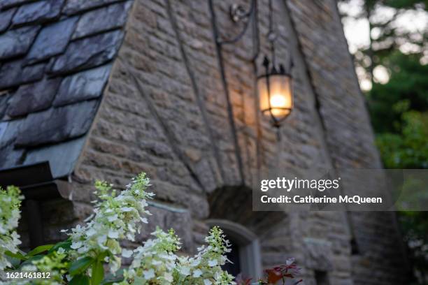 view of front door of stately tudor home (illuminated light) - home front stock pictures, royalty-free photos & images