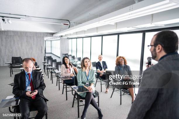 businessman talking to employee/coworkers during a seminar at office - brazil training and press conference stock pictures, royalty-free photos & images
