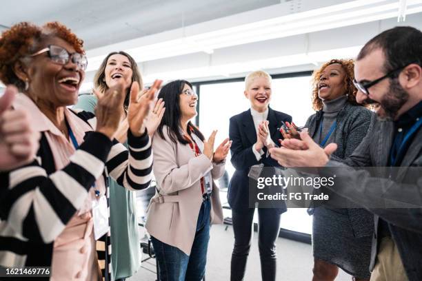 business people celebrating and applauding during a meeting at office - bedrijfscultuur stockfoto's en -beelden