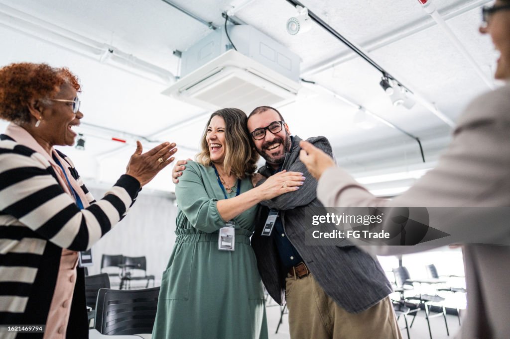 Happy coworkers embracing during a meeting at office