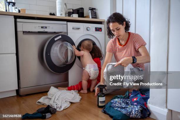 mother and her son and daughter do laundry together - afazeres domésticos imagens e fotografias de stock