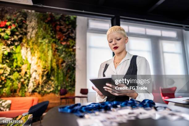 joven recepcionista usando una tableta digital en una conferencia de negocios - azafata fotografías e imágenes de stock
