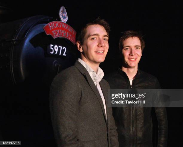 Twin actors Oliver Phelps and Jamie Phelps pose in front of the Hogwarts Express at Harry Potter:The Exhibition at Discovery Times Square on February...